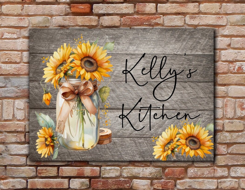 May include: A rustic wooden sign with the text "Kelly's Kitchen" in black script. The sign is decorated with a mason jar filled with sunflowers and a brown ribbon.