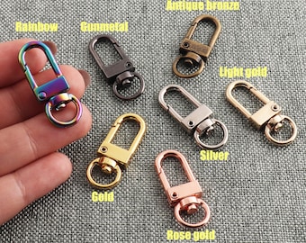 Puede incluir: Surtido de diez llaveros de metal en varios colores, incluyendo arcoíris, metal gris, bronce antiguo, oro claro, plata, oro y oro rosa. Cada llavero tiene un bucle simple de forma ovalada con un cierre de resorte.