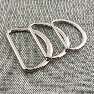 May include: Three silver metal D-rings of different sizes. The rings are stacked on top of each other.