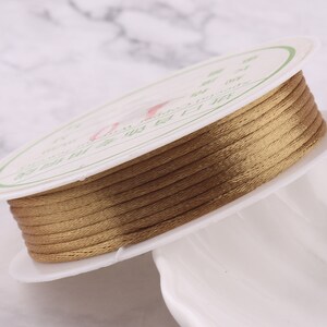 May include: A spool of gold-colored waxed cord, wound around a white plastic spool with Chinese text printed on the label.
