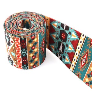 Op de afbeelding: Een opgerolde turquoise, bruine, rode en witte geweven band met geometrische patronen.