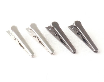 May include: A set of six metal clips, three silver and three black, for holding fabric or paper together.