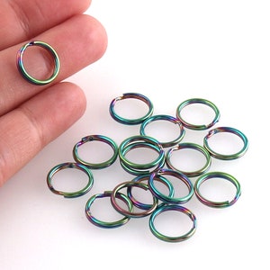 May include: A group of 15 iridescent rainbow coloured metal jump rings. The rings are approximately 2.5 cm in diameter.
