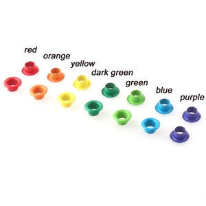 Peut inclure: Assortiment d'œillets métalliques colorés dans un schéma de couleurs arc-en-ciel, comprenant le rouge, l'orange, le jaune, le vert, le vert foncé, le bleu et le violet.