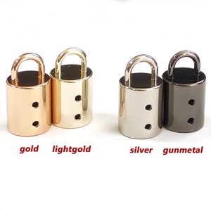 Puede incluir: Cuatro piezas de herrajes decorativos en forma de candado en oro, oro claro, plata y bronce.