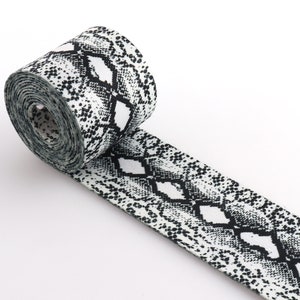 May include: White and black elastic ribbon with a snake skin pattern.