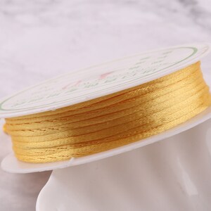 May include: A spool of yellow waxed cord, wound on a white plastic spool with green and black text in Chinese characters.