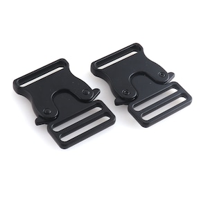 Puede incluir: Dos hebillas de liberación lateral de plástico negro. Las hebillas tienen un deslizador doble y están diseñadas para usarse con correas o cintas.