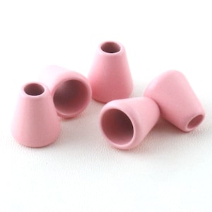 May include: Four pink plastic cord end stoppers. The stoppers are cone-shaped with a round hole at the top.
