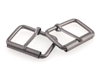 May include: Two silver metal belt buckle slides. The slides are rectangular with a rounded edge and a small metal loop on one side.