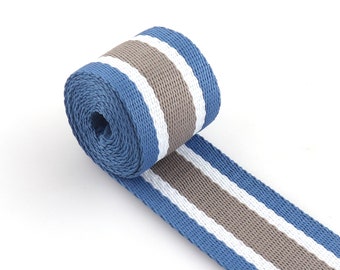 May include: A roll of blue and gray striped webbing. The webbing is woven with white stripes.