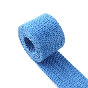 Puede incluir: Un rollo de cinta azul, un tipo de tejido tejido que se utiliza a menudo para correas y cinturones.