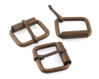 May include: Three antique gold-toned metal belt buckles. Each buckle has a rectangular shape with a smooth, slightly textured surface.