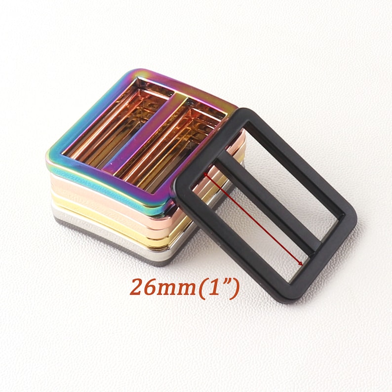 K&ouml;nnte beinhalten: Ein Stapel regenbogenfarbener Metall-Schieber-Schnallen, jede 26 mm (1 Zoll) breit. Die Schnallen sind aus strapazierf&auml;higem Metall gefertigt und haben eine glatte, polierte Oberfl&auml;che.
