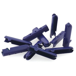 May include: A collection of navy blue plastic cord locks, scattered against a white background. Each lock has a rectangular body with small holes and a curved, slotted end. The locks appear to be new and unused.
