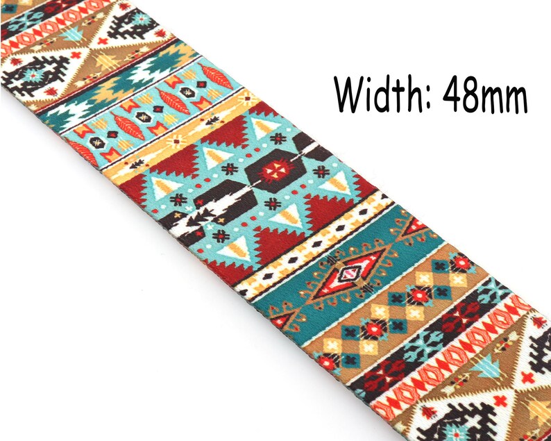Op de afbeelding: Een kleurrijke gitaarband met een geometrisch patroon in tinten rood, blauw, geel en bruin. De band is 48 mm breed.