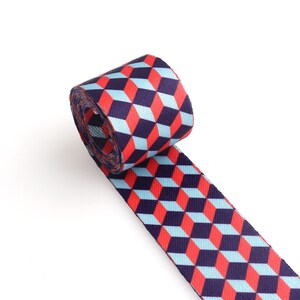 May include: A roll of blue, red, and white patterned webbing. The webbing has a geometric design of cubes.