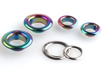 Op de afbeelding: Assortiment van kleurrijke metalen oogjes in verschillende maten. De oogjes hebben een regenboogkleurige, iriserende afwerking.