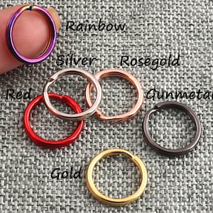 May include: Assortment of key rings in various colors, including rainbow, silver, rose gold, gunmetal, red, and gold.