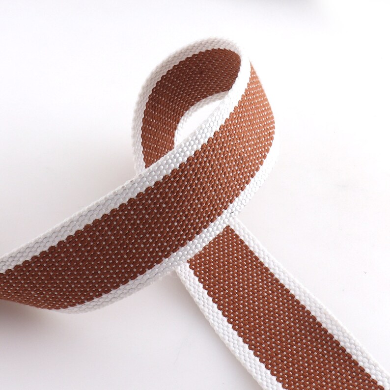 May include: Brown and white striped cotton webbing. The webbing is woven with a textured pattern.