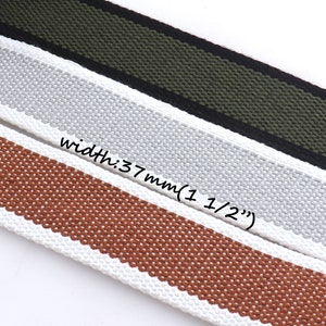 May include: Three different colored woven cotton webbing straps with white edges. The straps are 1 1/2 inches wide and are shown in brown, gray, and black and green stripes.