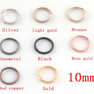 May include: Assortment of 10mm jump rings in various metal finishes: silver, light gold, bronze, gunmetal, black, rose gold, red copper, and gold.
