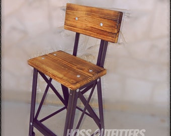 May include: A rustic wooden bar stool with a black metal frame. The seat and back are made of reclaimed wood with a natural finish. The stool has a simple, industrial design and is perfect for adding a touch of farmhouse style to any space. The stool is labeled "Hoss Outfitters".