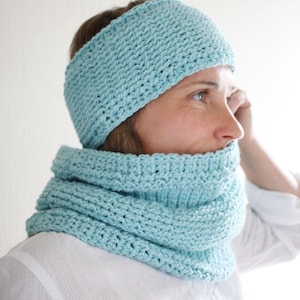Può includere: Un cerchietto e un scaldacollo abbinati in maglia blu chiaro. Il cerchietto si indossa sulla testa e lo scaldacollo si indossa intorno al collo.