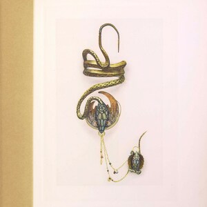May include: A gold snake-shaped bracelet with a coiled design and a dangling pendant featuring a snake head with red and blue accents. The pendant is attached to a chain with small beads.