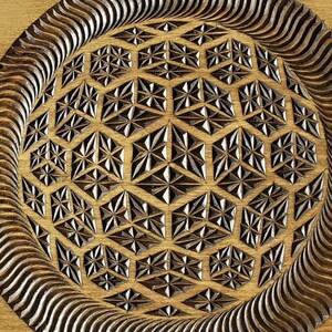 K&ouml;nnte beinhalten: Ein rundes Holztablett mit einem geschnitzten geometrischen Muster in der Mitte. Das Muster ist ein sich wiederholendes Design aus Sternen und Diamanten. Das Tablett hat eine dunkelbraune Beize und eine nat&uuml;rliche Holzoptik.