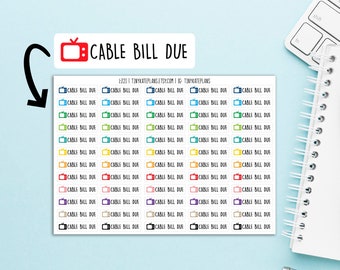 May include: Sheet of colorful planner stickers with the text "CABLE BILL DUE" and a TV icon. The stickers are in various colors, including blue, green, yellow, orange, red, purple, and black. A white notebook, glasses, and a keyboard are in the background.