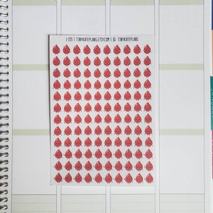 May include: A sheet of red blood drop stickers with a happy face. The stickers are arranged in a grid pattern. The sheet has the text "L-133 | TINYKATEPLANS.ETSY.COM | IG: TINYKATEPLANS" printed on it.