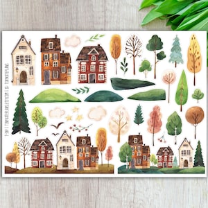 May include: A sticker sheet featuring watercolor illustrations of houses, trees, clouds, and other landscape elements. The houses are in various styles with brown, orange, and white facades. The trees display green, yellow, and brown foliage. The text "T-187 | TINYKATEPLANS.ETSY.COM" is visible.