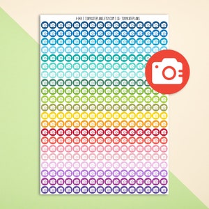 May include: A sheet of colorful camera stickers with a variety of colors including blue, green, yellow, orange, red, pink, purple, and white. The stickers are arranged in rows and columns. Each sticker features a white camera icon.