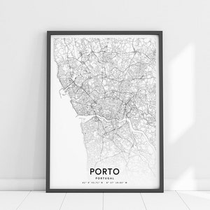 May include: A black and white map print of Porto, Portugal, in a black frame. The map shows the city's streets and waterways. The text "PORTO" and "PORTUGAL" are printed below the map, along with the coordinates "41&deg; 9' 43.71" N 8&deg; 37' 19.03" W".