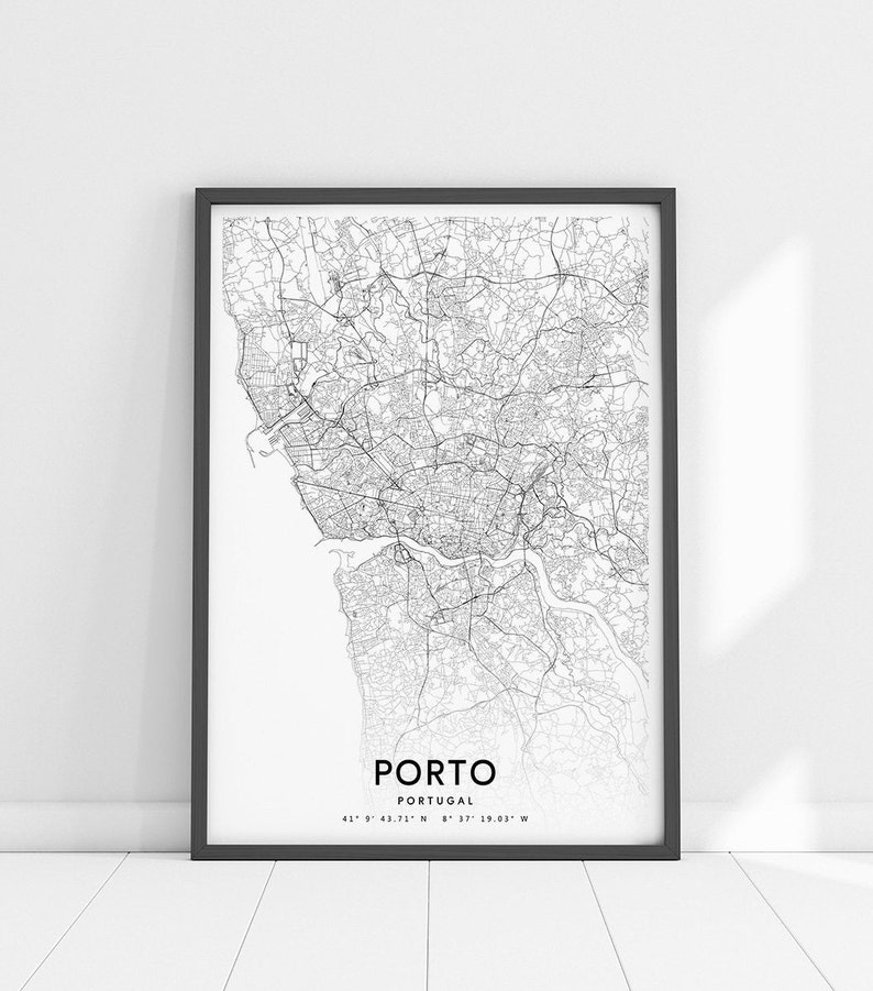 May include: A black and white map print of Porto, Portugal, in a black frame. The map shows the city's streets and waterways. The text "PORTO" and "PORTUGAL" are printed below the map, along with the coordinates "41&deg; 9' 43.71" N 8&deg; 37' 19.03" W".