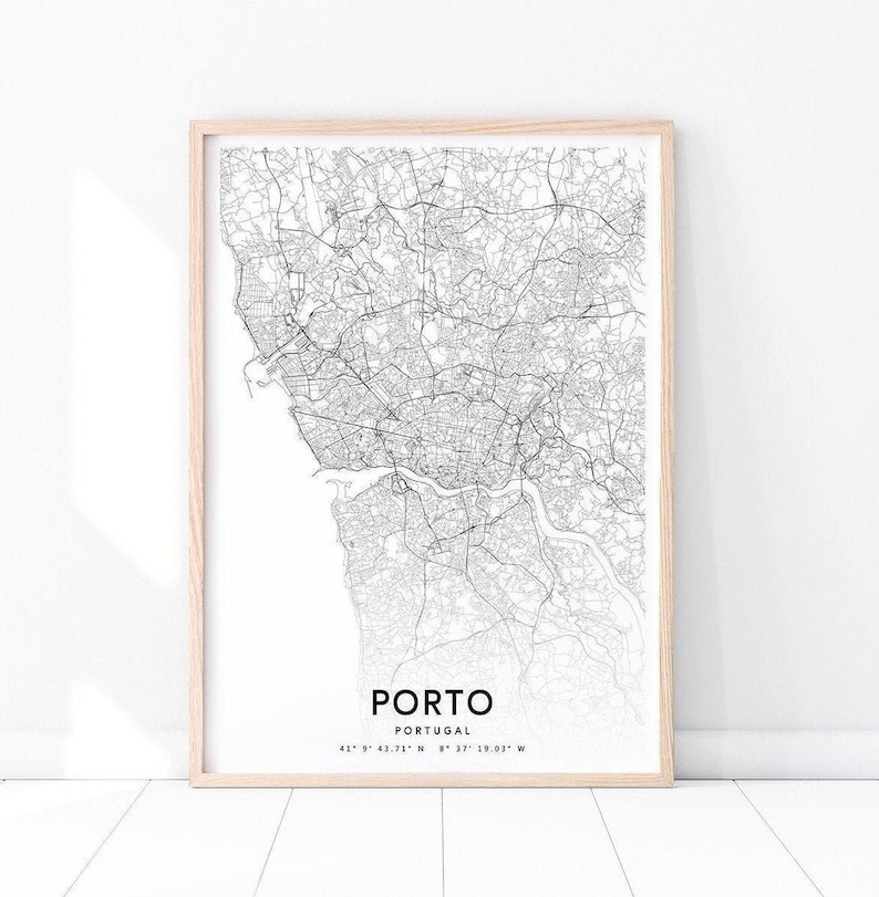 May include: A black and white map print of Porto, Portugal, with the city's name and coordinates printed below the map. The map is framed in a light wood frame.