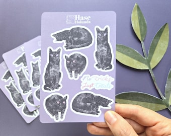 Könnte beinhalten: Ein hellvioletter Stickerbogen mit sechs Illustrationen schwarzer Katzen mit rosa Augen und dem Text No tricks Just treats. Der Markenname Hase Holunda ist oben aufgedruckt. Die Katzen sind in verschiedenen Sitz- und Liegepositionen dargestellt.