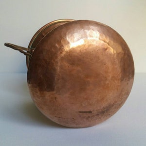 May include: A hammered copper pot with a lid and a handle. The pot is round and has a shiny finish.