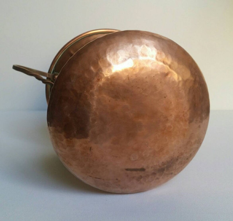 May include: A hammered copper pot with a lid and a handle. The pot is round and has a shiny finish.