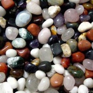 May include: A collection of smooth, polished stones in various colors, including white, pink, red, black, and green. The stones are tumbled and have a natural, earthy look.