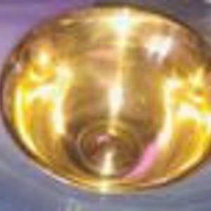 Puede incluir: Un tazón de metal dorado brillante con una superficie reflectante.