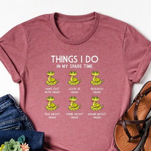 May include: A maroon t-shirt with a white graphic of snakes and the text "Things I do in my spare time".