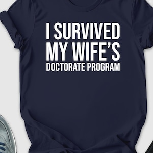 I Survived My Wife's Doctorate Program Shirt, Husband Tee, Funny PHD Graduation Gift, PHD Dissertation Shirt, Sarcastic Gift For PHD Husband