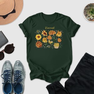 a collection of various items, including a green t-shirt with a floral design, sunglasses, a hat, a wallet, a pair of sneakers, and a pair of pants.
