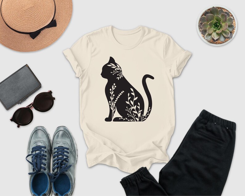 a casual outfit consisting of a white t-shirt with a black cat silhouette, a pair of gray sneakers, a pair of black pants, sunglasses, a hat, and a small potted succulent plant.