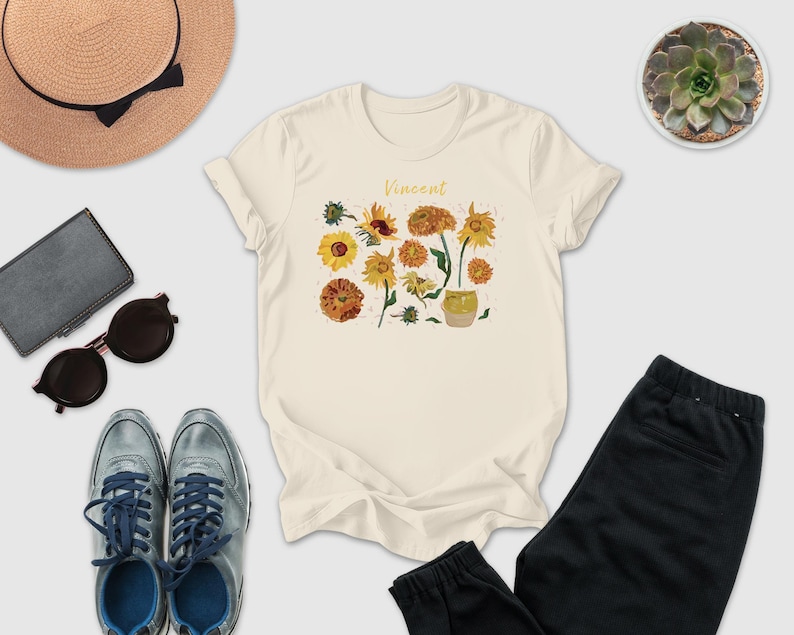 a casual outfit consisting of a white t-shirt with a floral design, a pair of sunglasses, a hat, a wallet, a pair of sneakers, and a pair of pants.