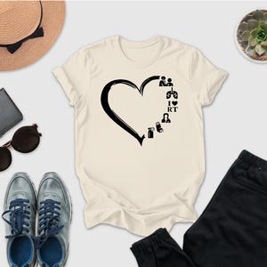 a casual outfit consisting of a white t-shirt with a heart design, a pair of gray sneakers, a hat, sunglasses, a wallet, a potted succulent plant, and a pair of black pants.