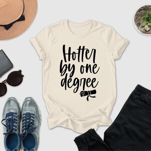 a casual outfit consisting of a white t-shirt with a black text design, a pair of black pants, a pair of sunglasses, a hat, and a small potted plant.