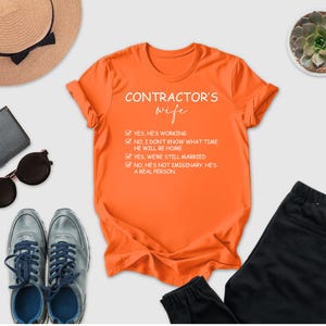 a variety of items, including a hat, sunglasses, a t-shirt, a pair of pants, a wallet, a phone, and a succulent plant, all arranged on a white background.
